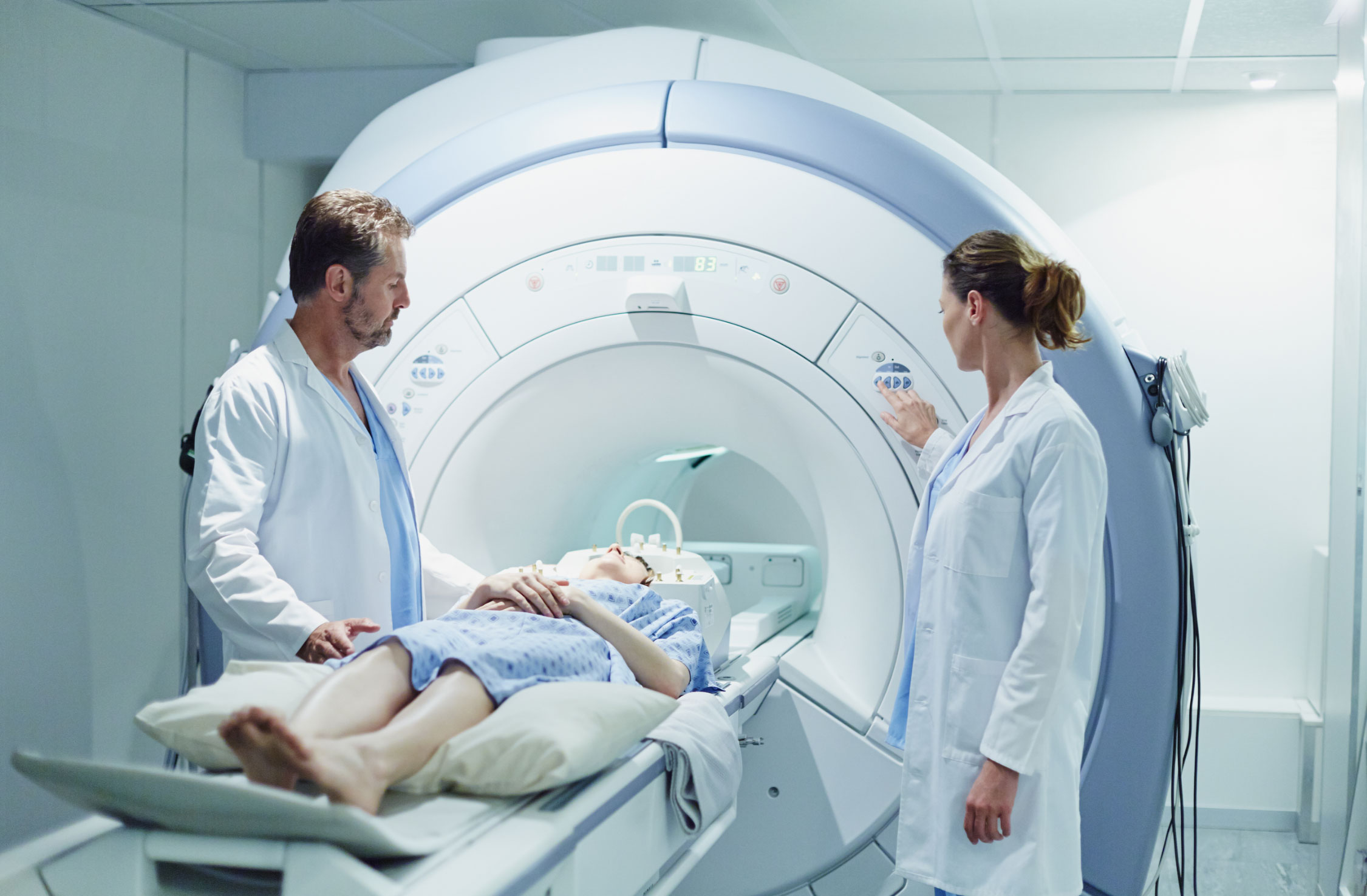 HCI-home-feature Two Doctors around patient bed during CAT Scan